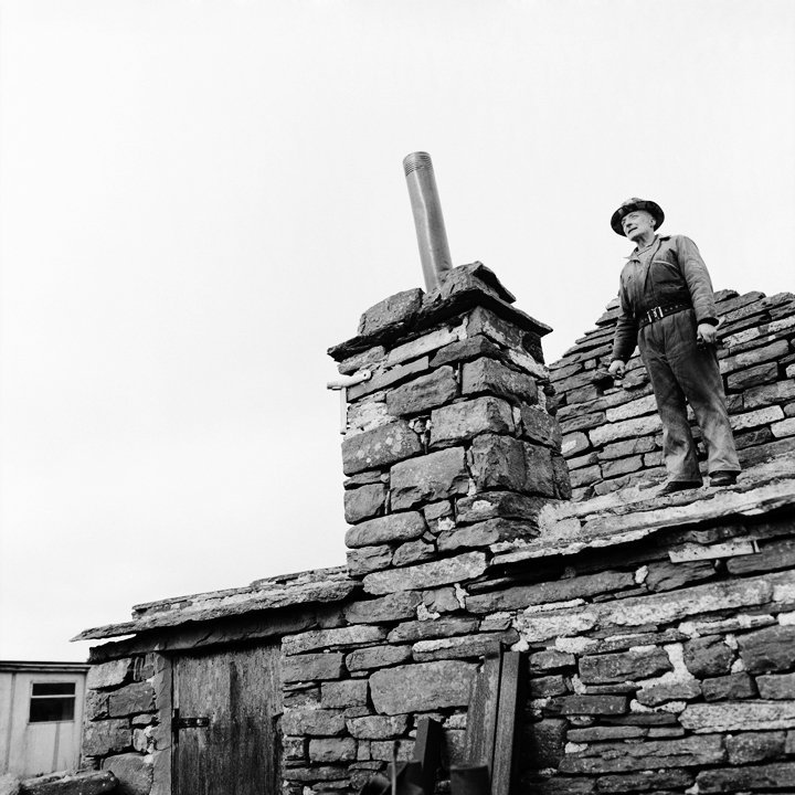 (Jimmie O'Lochend). On his roof of Lochend, fixing his chimney. North Ronaldsay. (Jimmie O'Lochend). On his roof of Lochend, fixing his chimney. North Ronaldsay.