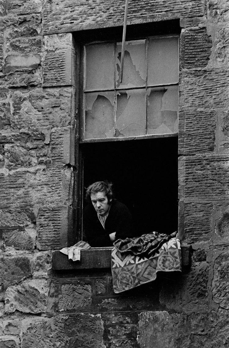 Unemployed colliery worker Glasgow tenement © Nick Hedges/Shelter 1971 "They are the grimmest environment that I’ve encountered. This has something to do with the size of the stone used in their construction, the entry to them through the cave like entrances, the deep and dark stairwells and the relentless pattern of streets. The tenements are built around a courtyard which becomes a battlefield and refuse dump." - Nick Hedges